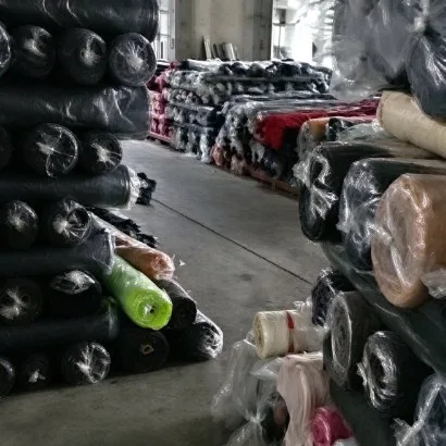 Rows of wrapped fabric rolls in a supplier's covered store