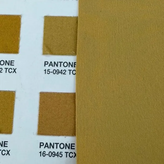 Woven fabric laid beside Pantone TCX swatches under even light