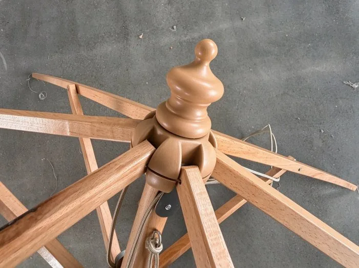 Wooden patio umbrella frame close-up showing ribs, hub and pole joints
